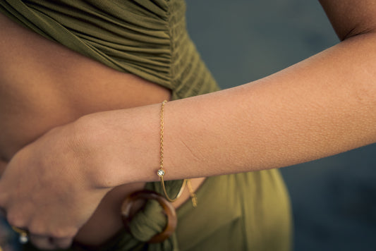 Gold bracelet on a wrist with a blurred background