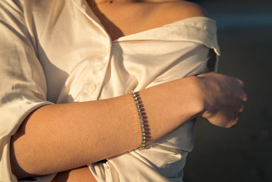 Women wearing a white shirt with a Tennis bracelet on a blurred background