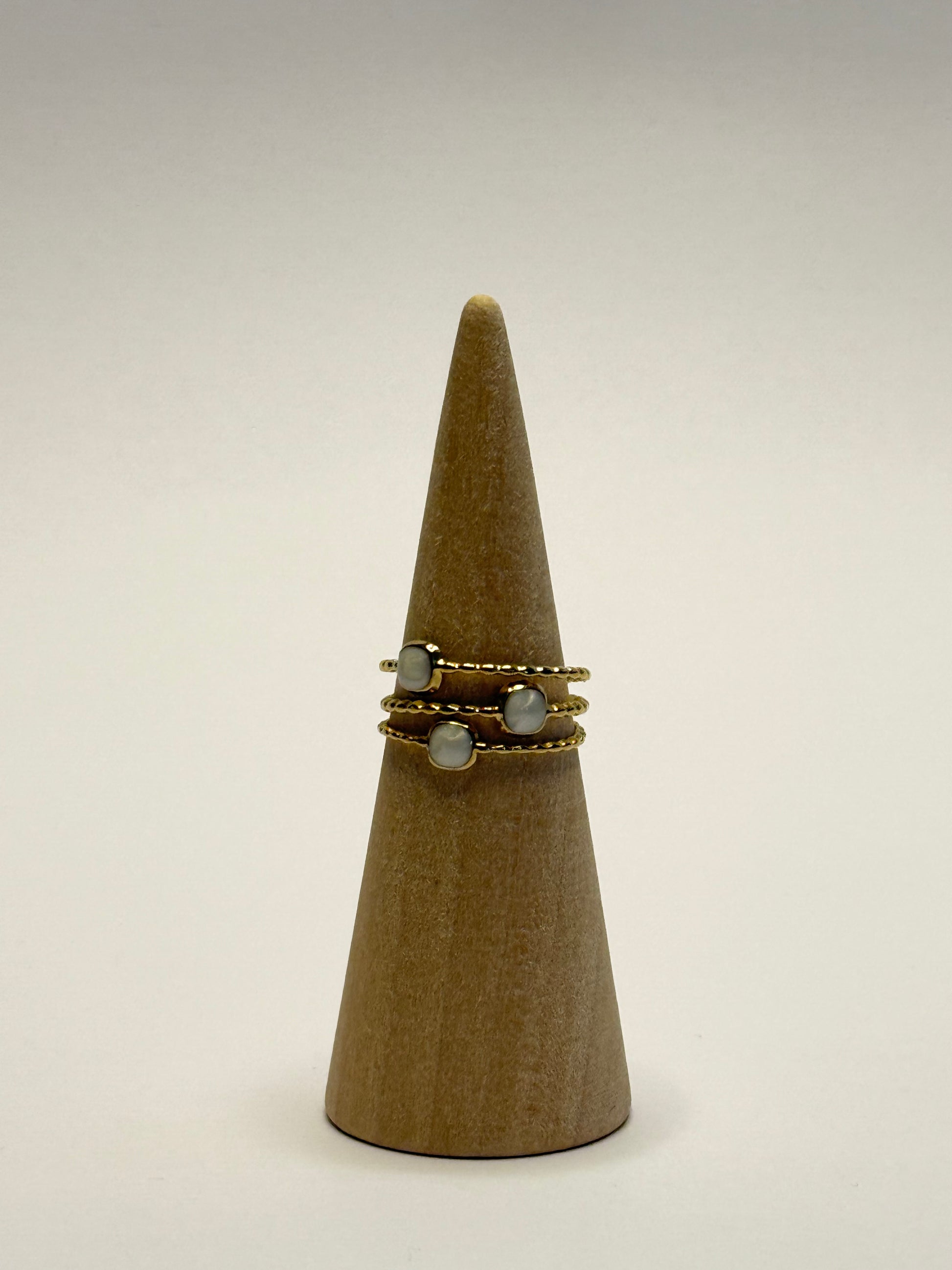 Ring on a wooden cone with a plain background