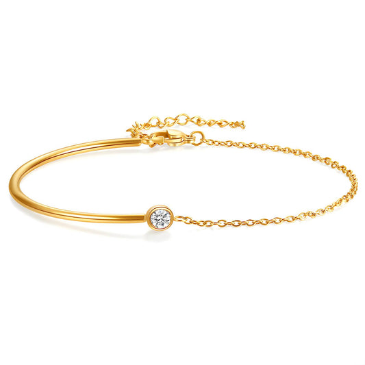 Gold bracelet with a cubic zirconia stone on a white background