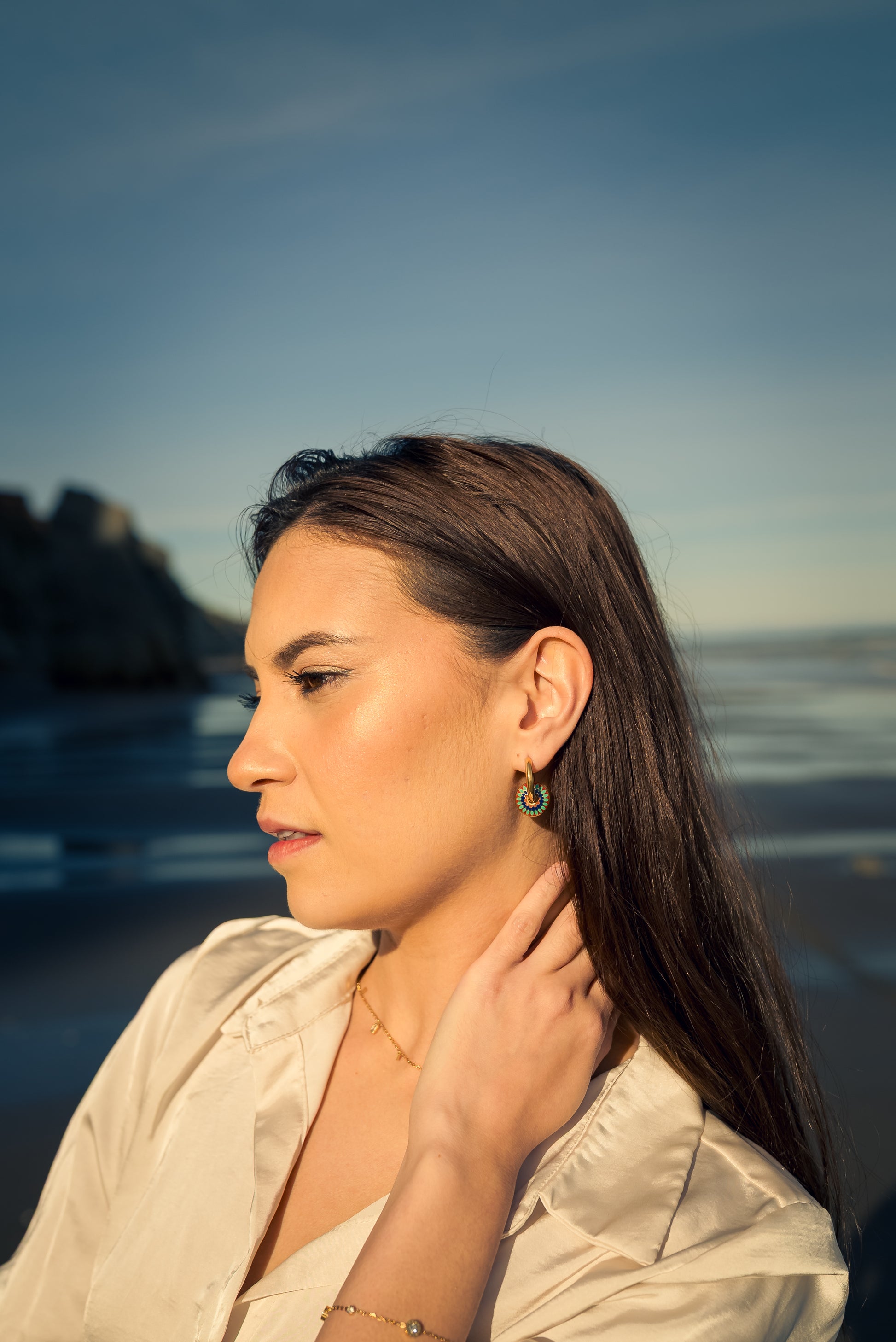 Woman wearing Kaleidora Hoops earring with a scenic background