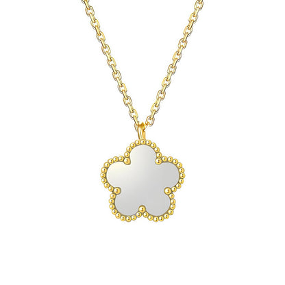 Gold necklace with a white pendant on a white background