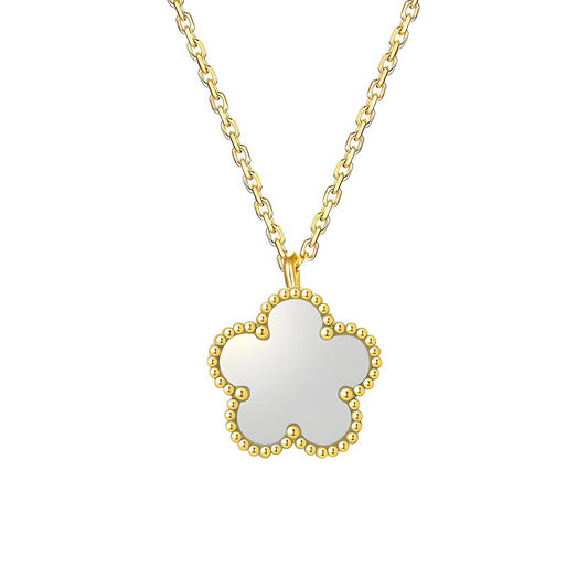 Gold necklace with a white pendant on a white background