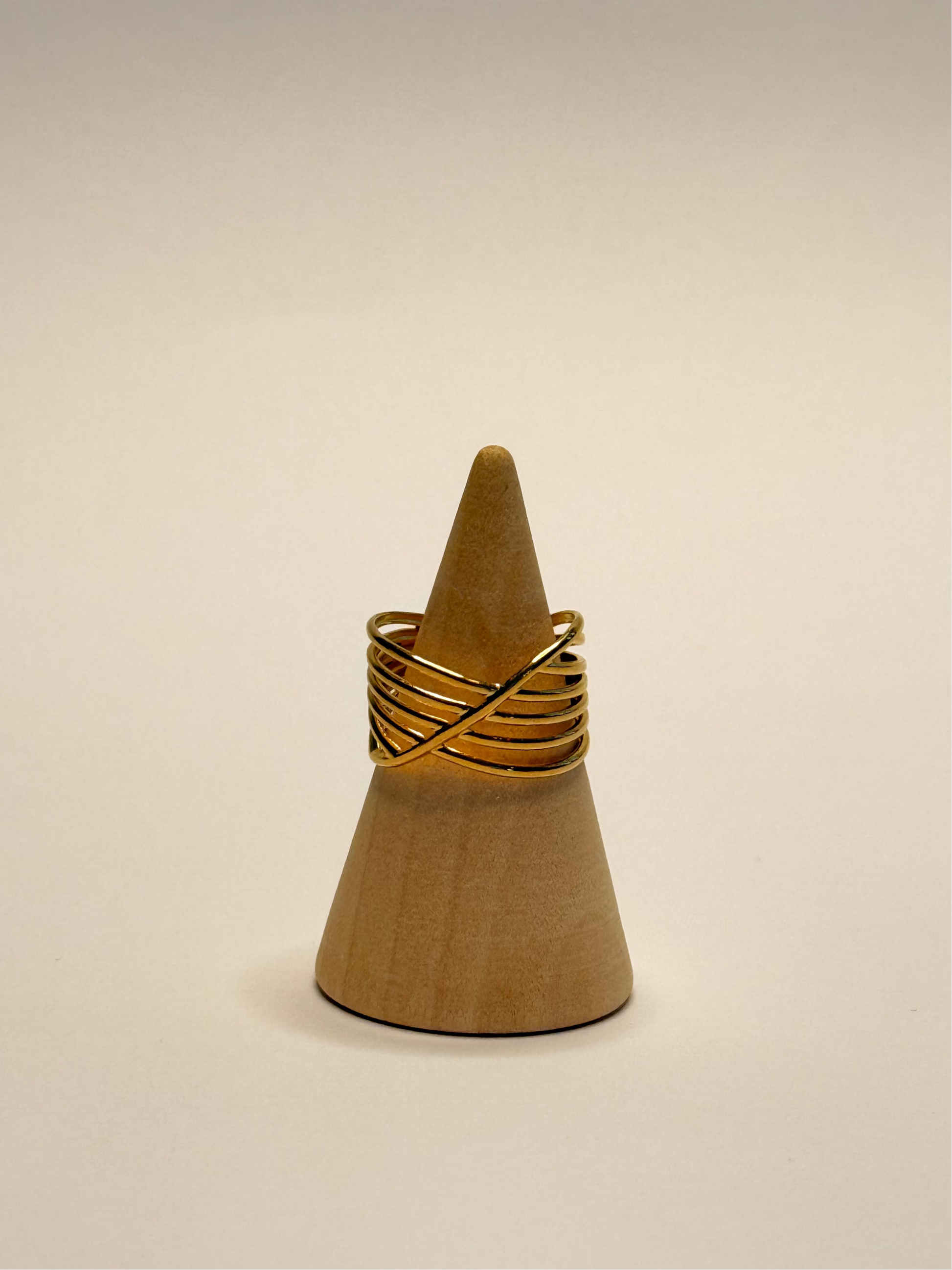 Wooden cone with a gold ring on a beige background