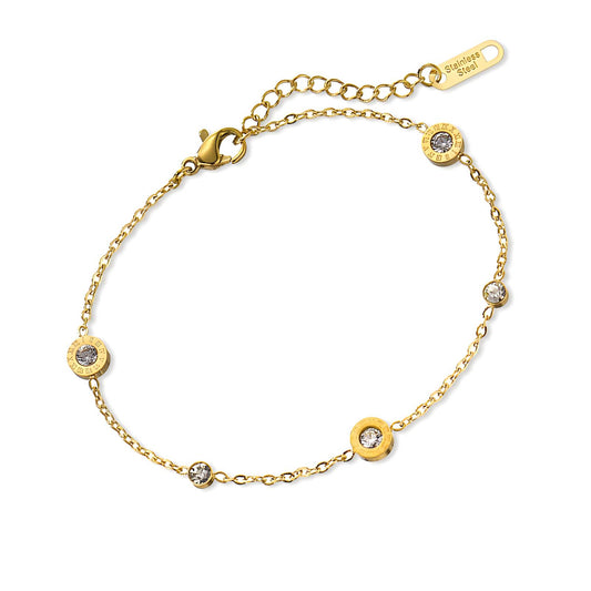 Gold bracelet with gemstone accents on a white background