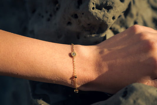 Gold bracelet with Cubic zirconia stones on a wrist with a blurred natural background
