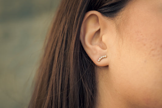Close-up of an ear with Serene Pearl Earrings earring against a blurred background